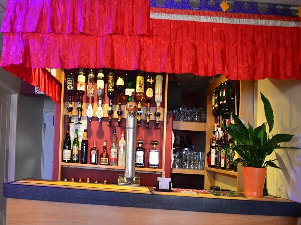The bar, with red curtains and shelves of bottles